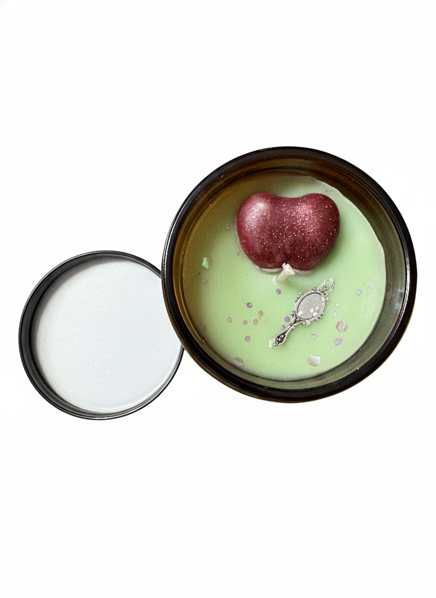 Candle with a decorative apple and silver spoon inside on a white background