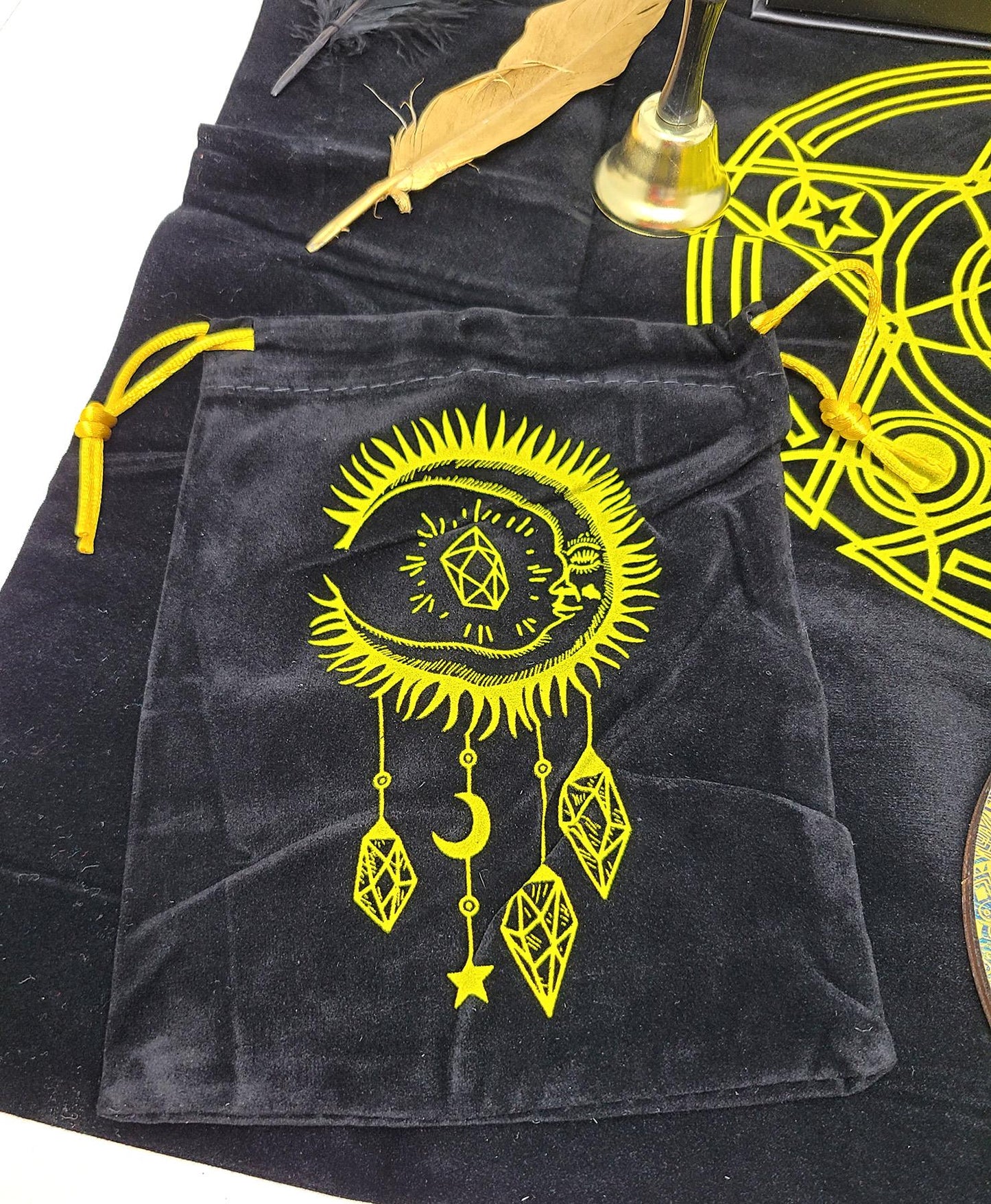 Black velvet pouch with yellow celestial design on a dark surface.