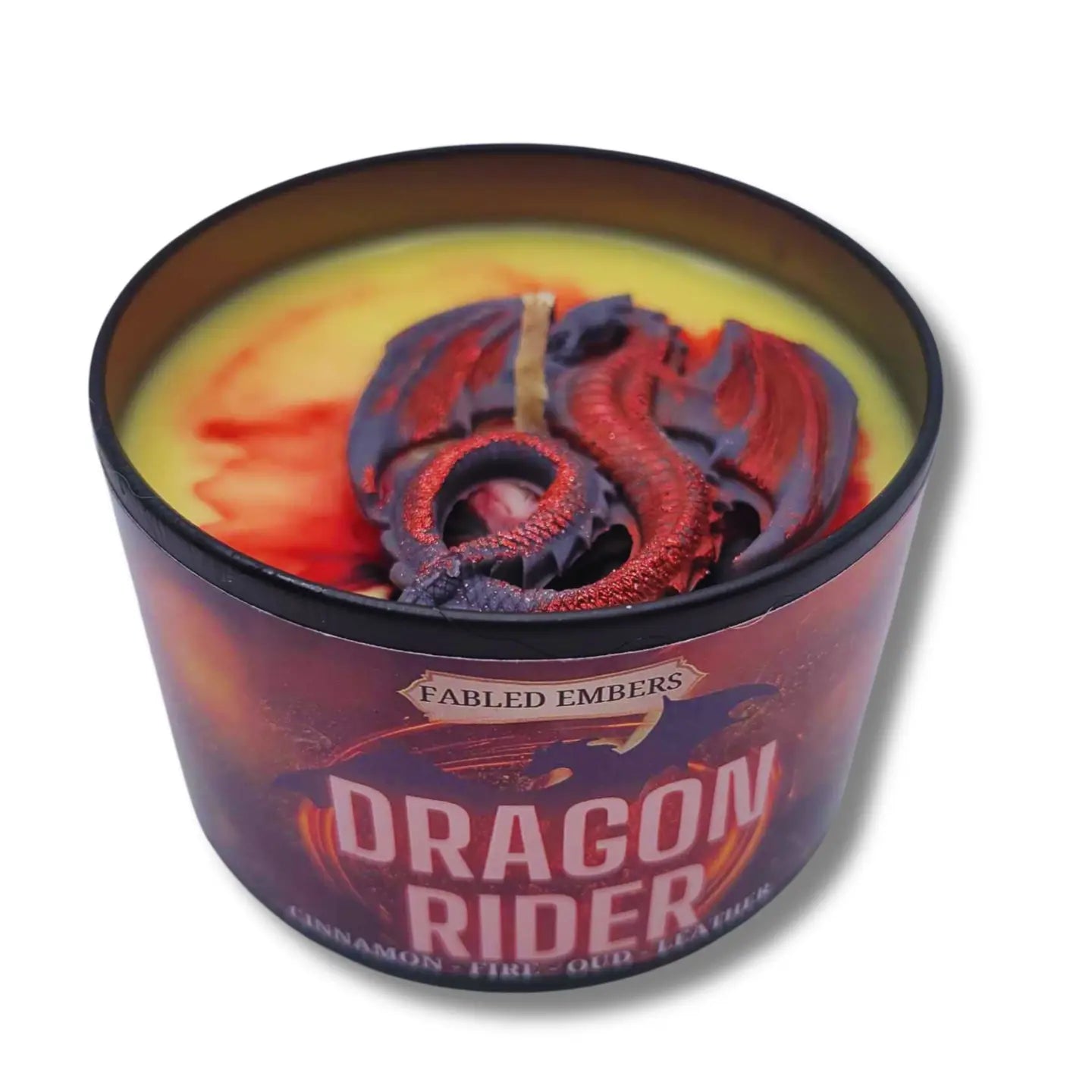 Candle in a tin labeled 'Dragon Rider' with colorful wax design on a white background