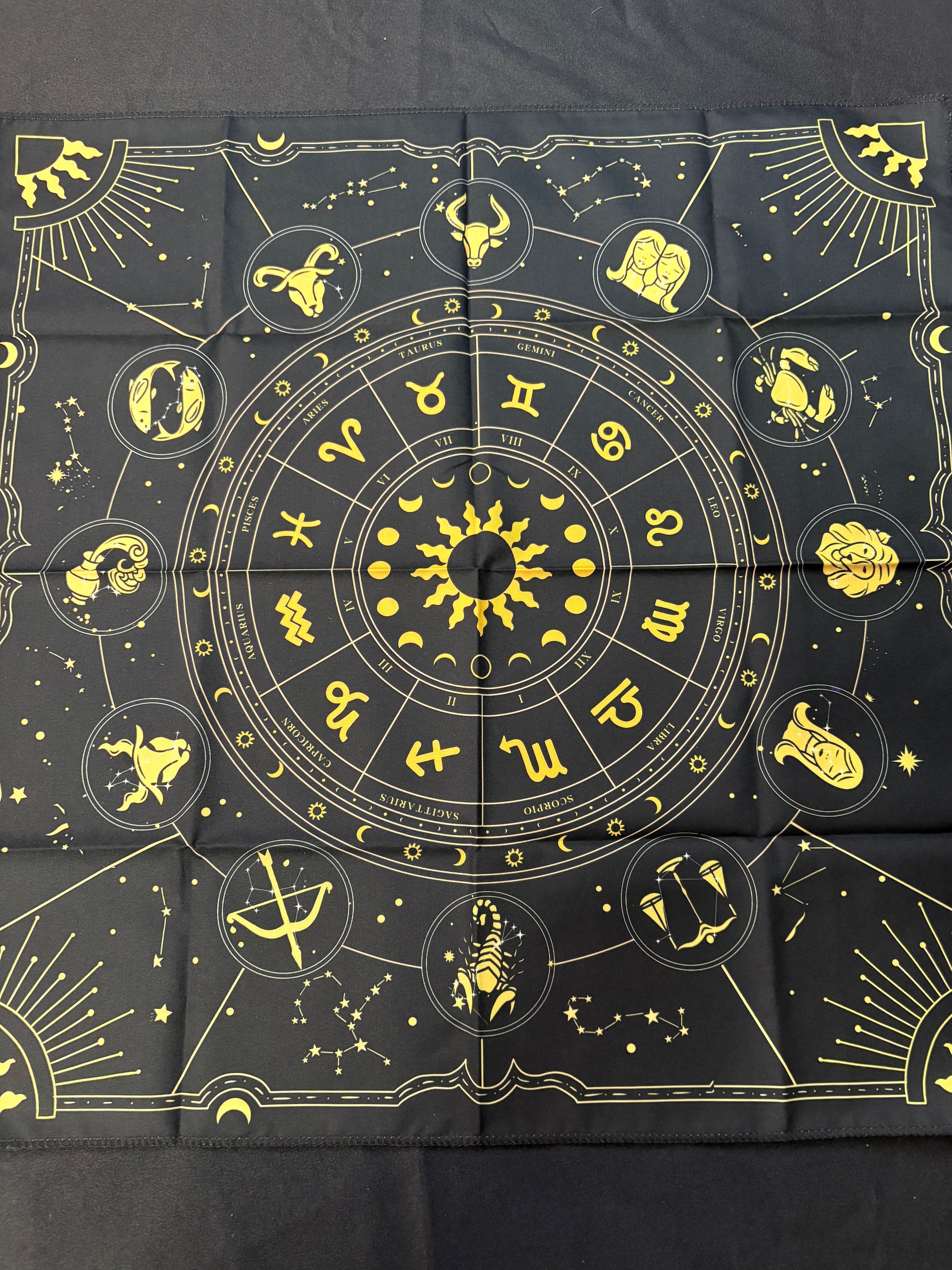 Black fabric with yellow zodiac symbols arranged in a circular pattern