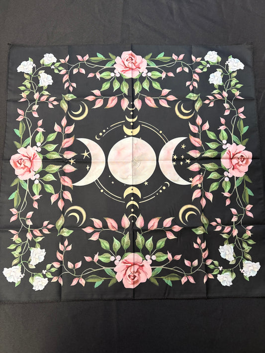 Decorative cloth with floral and moon symbol design on a black background