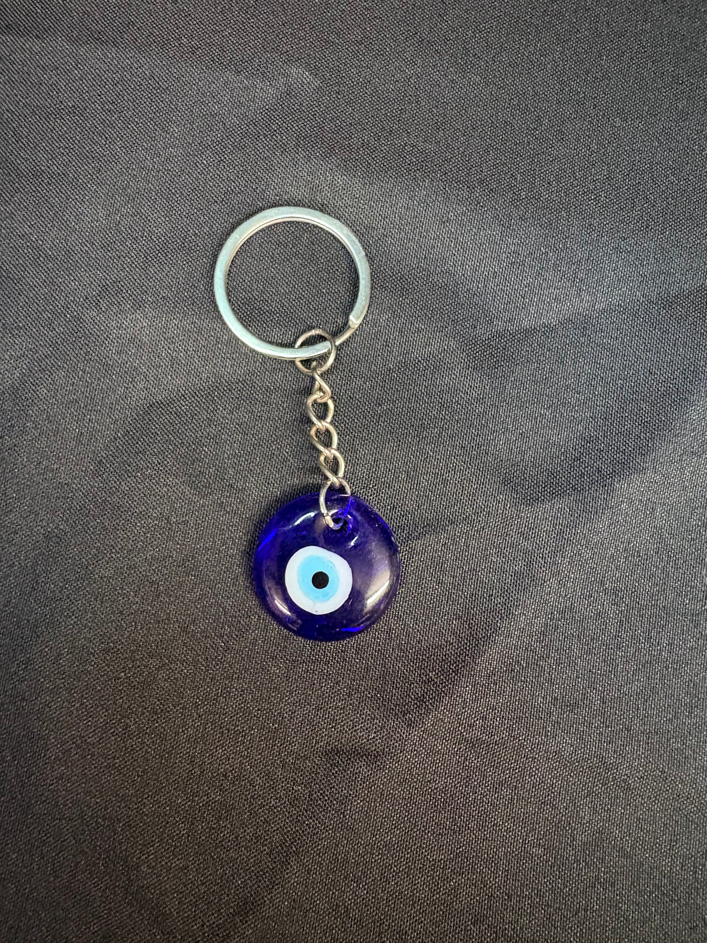 Keychain with a blue evil eye charm on a gray background