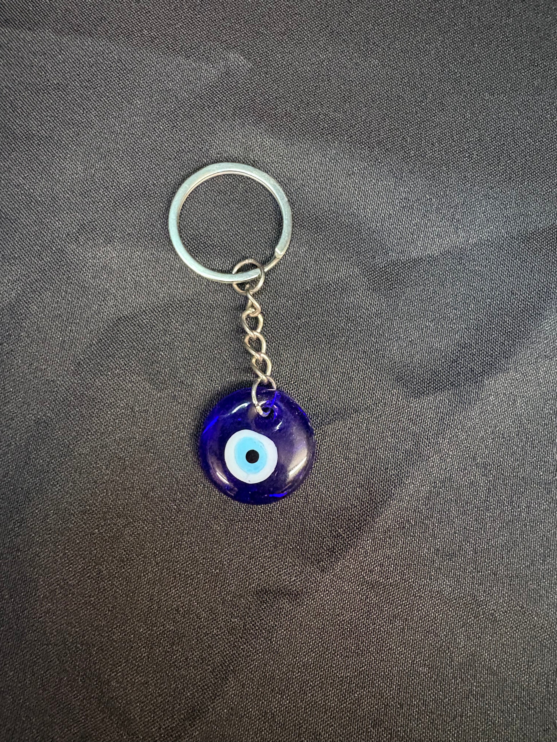 Keychain with a blue evil eye charm on a gray background