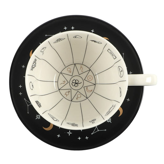Ceramic cup with astrological design on a black saucer