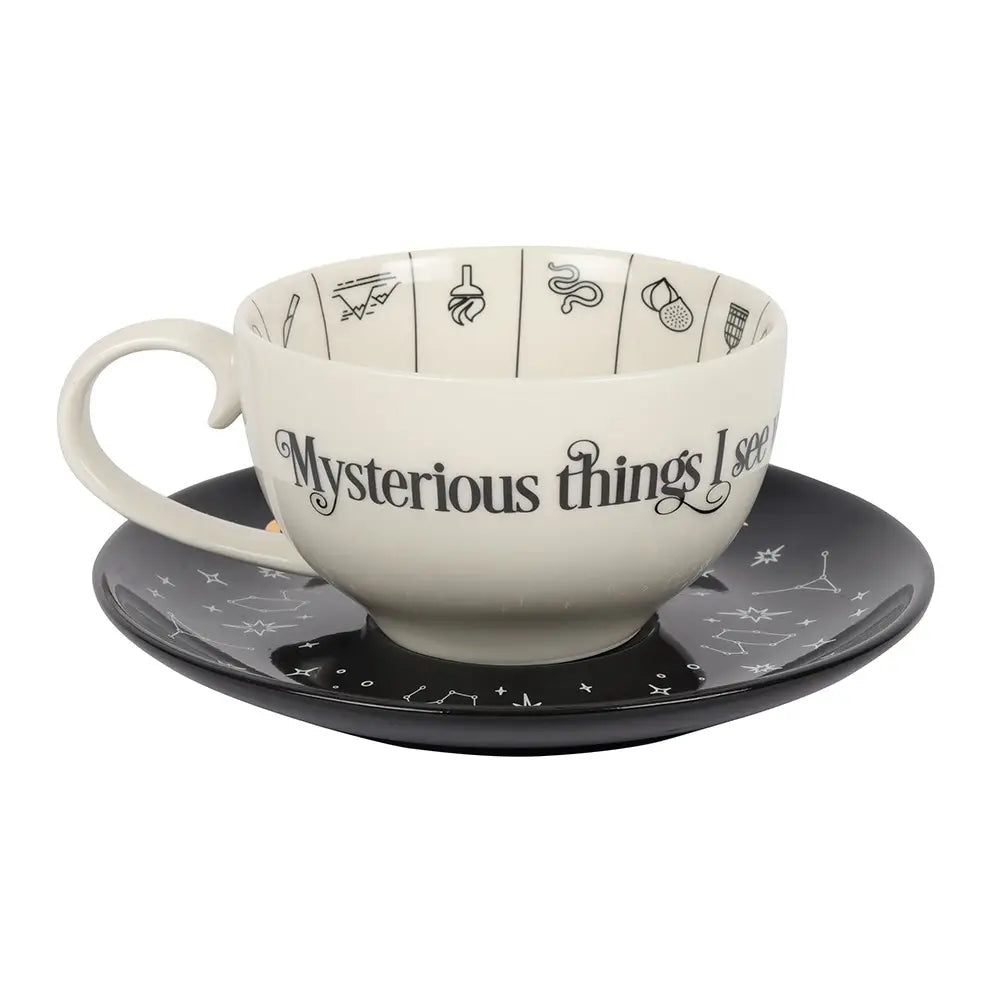 Ceramic cup and saucer with 'Mysterious things seem' text on a white background
