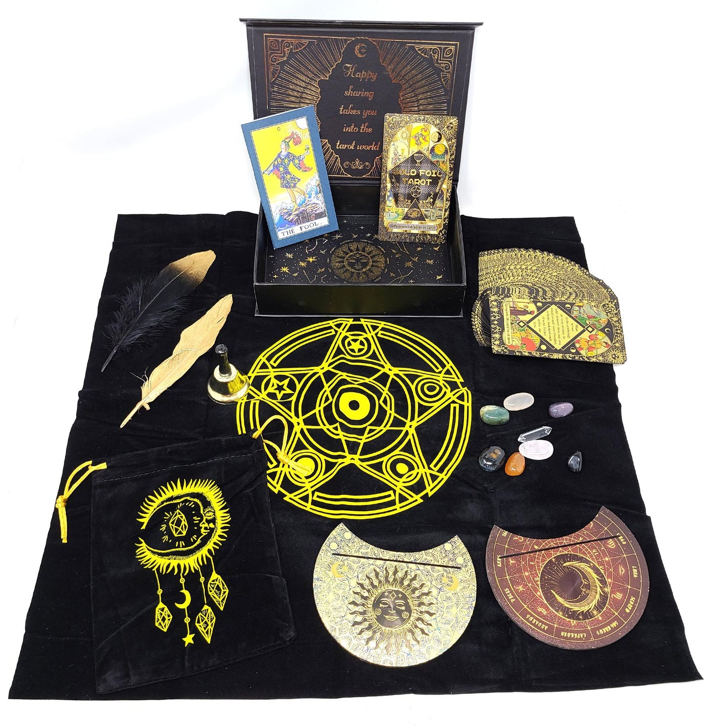 Witchcraft kit with tarot cards, crystals, and decorative items on a black cloth with celestial designs.