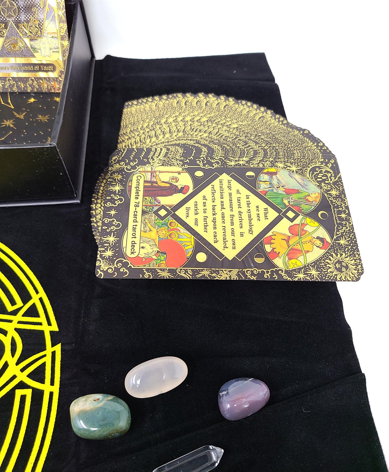 Tarot cards with decorative cover and three crystals on a black surface